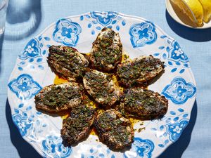 Cooked chermoula sardines arranged on a decorative plate with a garnish