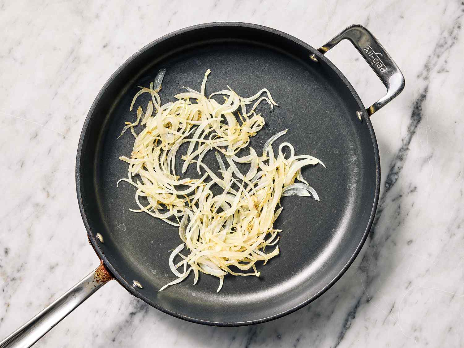 Pan with sautéed onions, cooking on a stove