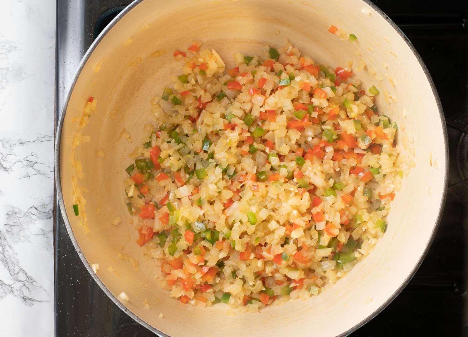 Diced vegetables in a Dutch oven.