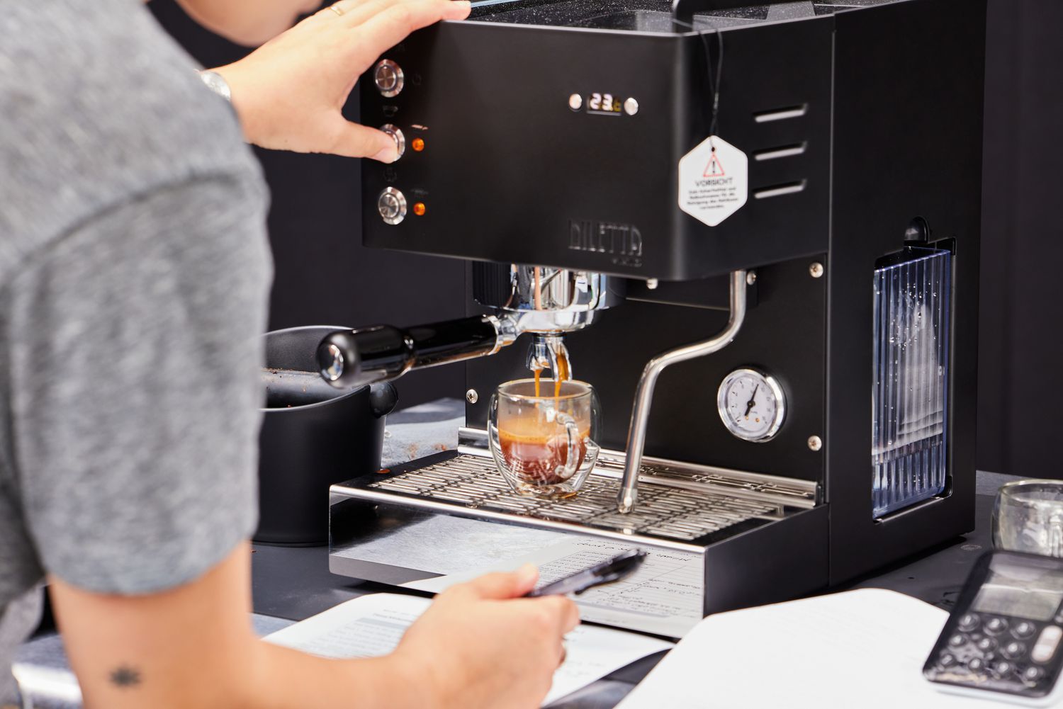 Person pressing a button on the Diletta Mio Espresso Machine as it brews an espresso 