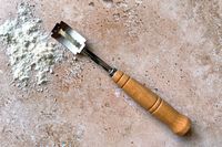 The Saint German Premium bread lame on a counter next to a pile of flour