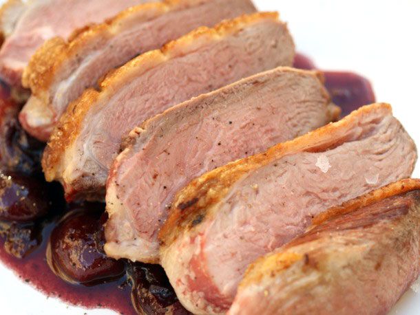 Sliced duck breast with cherry sauce.