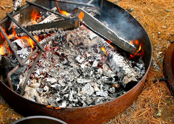 A campfire with lots of hot coals and a space to set a Dutch oven.