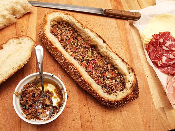 olive salad layered on bottom half of hollowed out crusty loaf