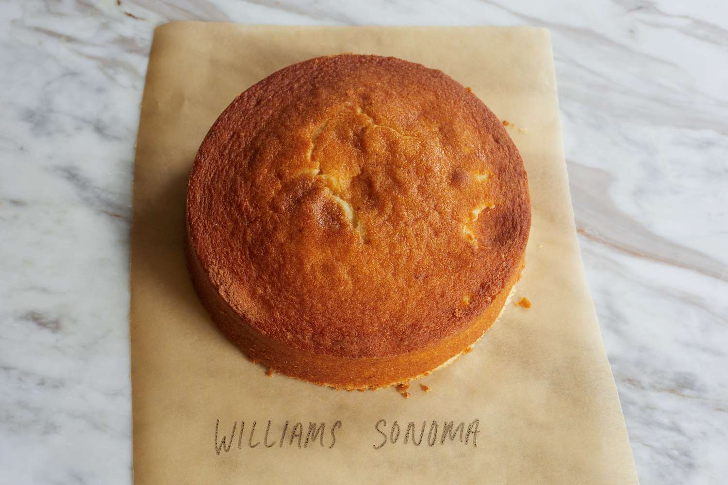 A cake on a piece of parchment on a marble surface