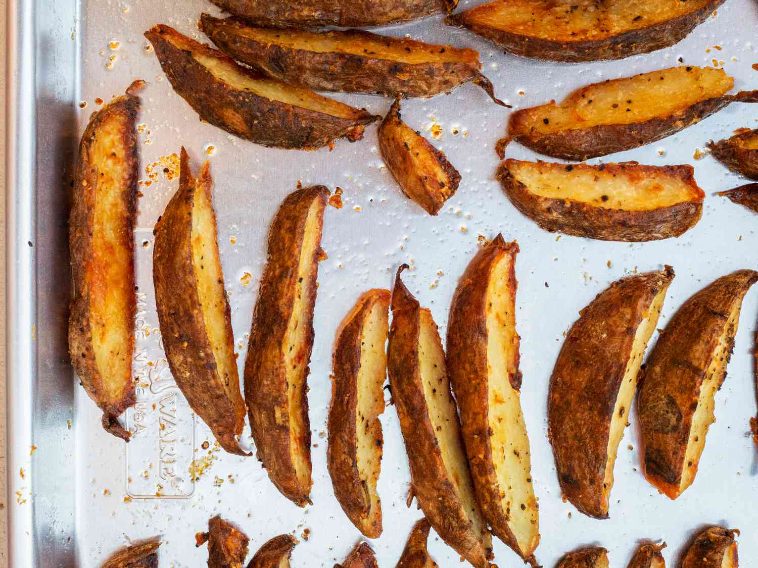 Cooked potato wedges on Nordic Ware Naturals Baker's Half Sheet