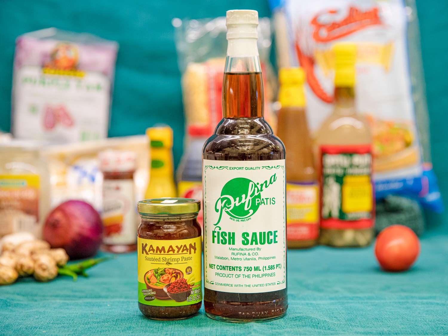 A bottle of Kamayan Shrimp paste placed next to a bottle of Rufina Fish Sauce