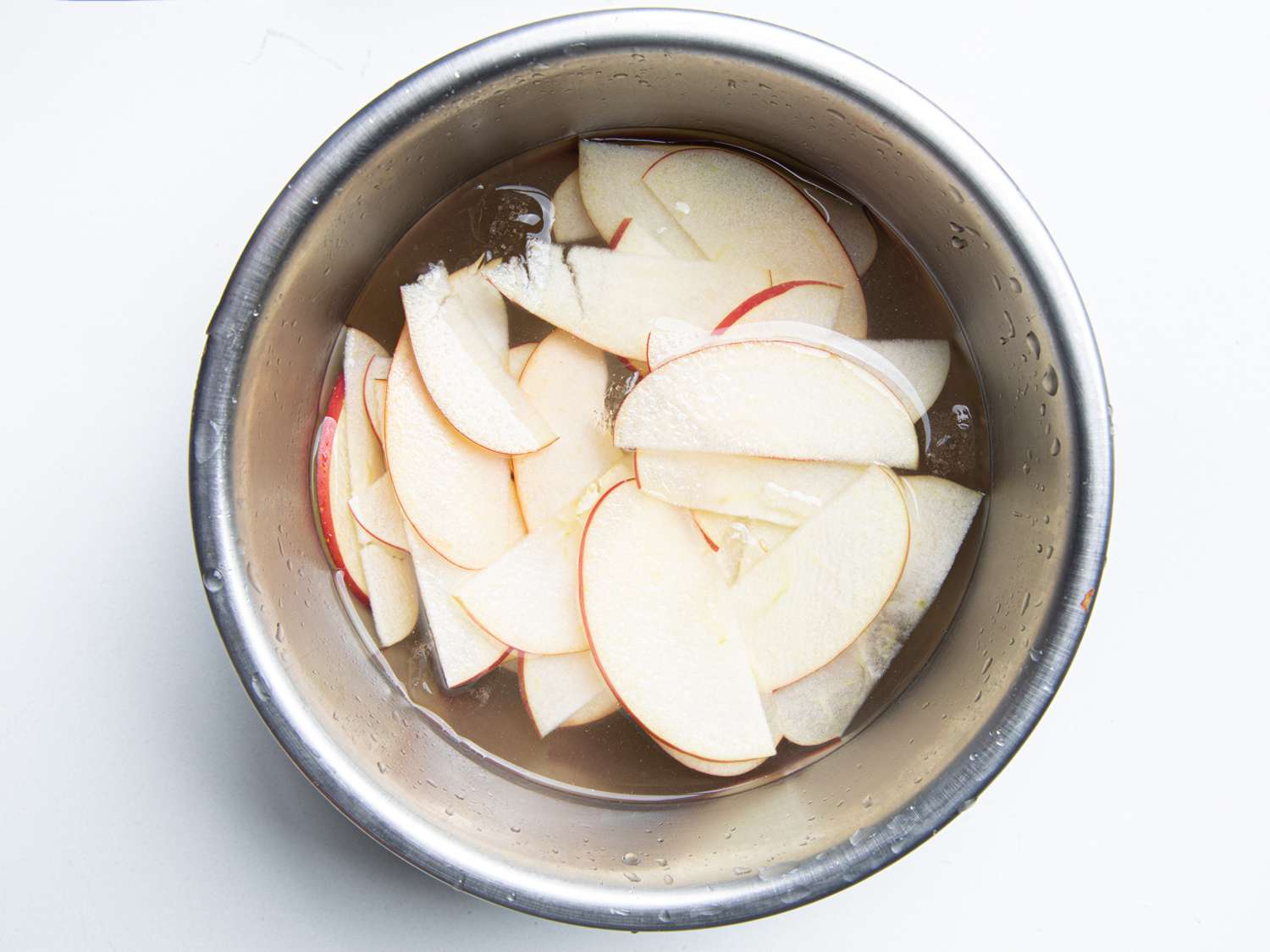 Cut apples in a metal bowl with water