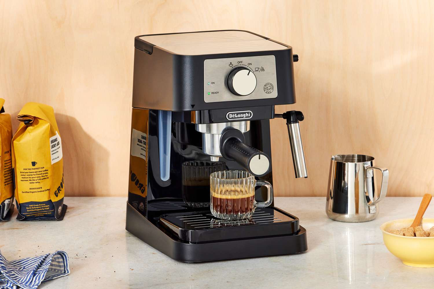 The De'Longhi Stilosa Espresso Machine brewing an expresso on a white marble countertop