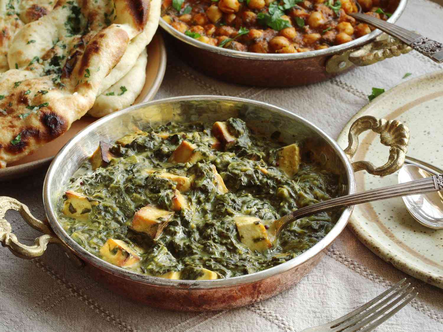 Creamy vegan saag paneer, ready to sereve with naan and chana masala.