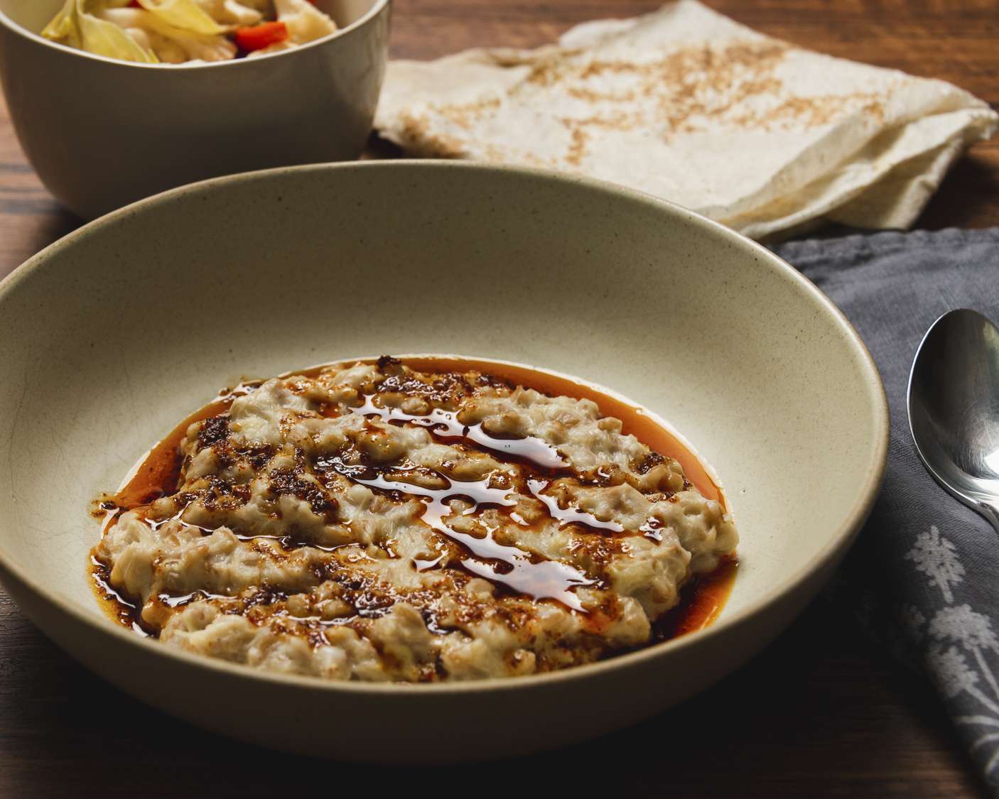 Angled view of harissa in a bowl topped with Aleppo browned butter