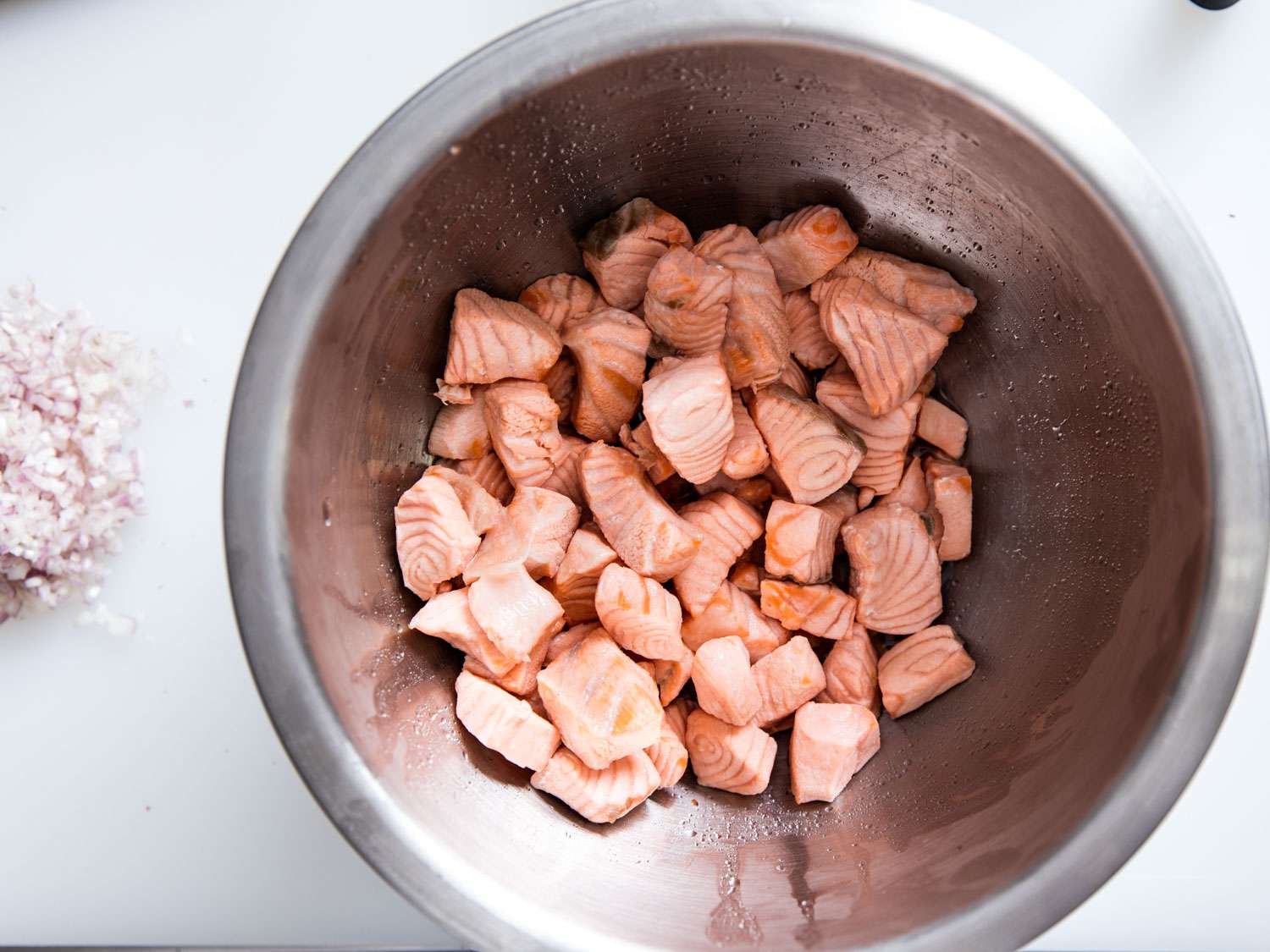 Cubes of poached salmon in a bowl for rillettes.