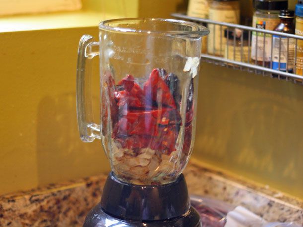 Drained red chiles in a blender with onions and garlic.