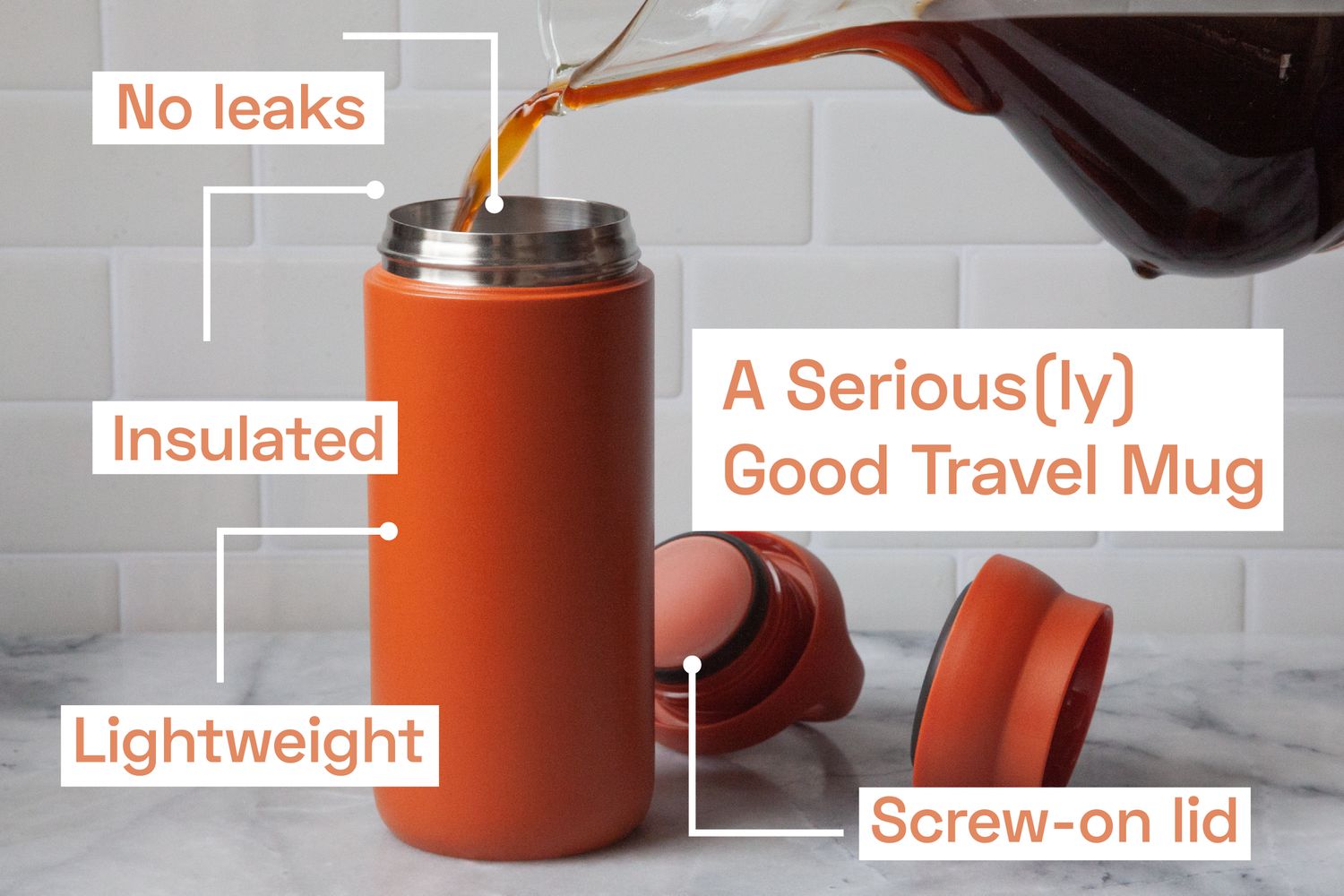 Coffee being poured into an orange travel mug.