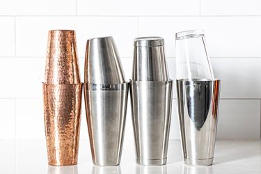 four boston shakers (made of different materials) on a grey countertop 