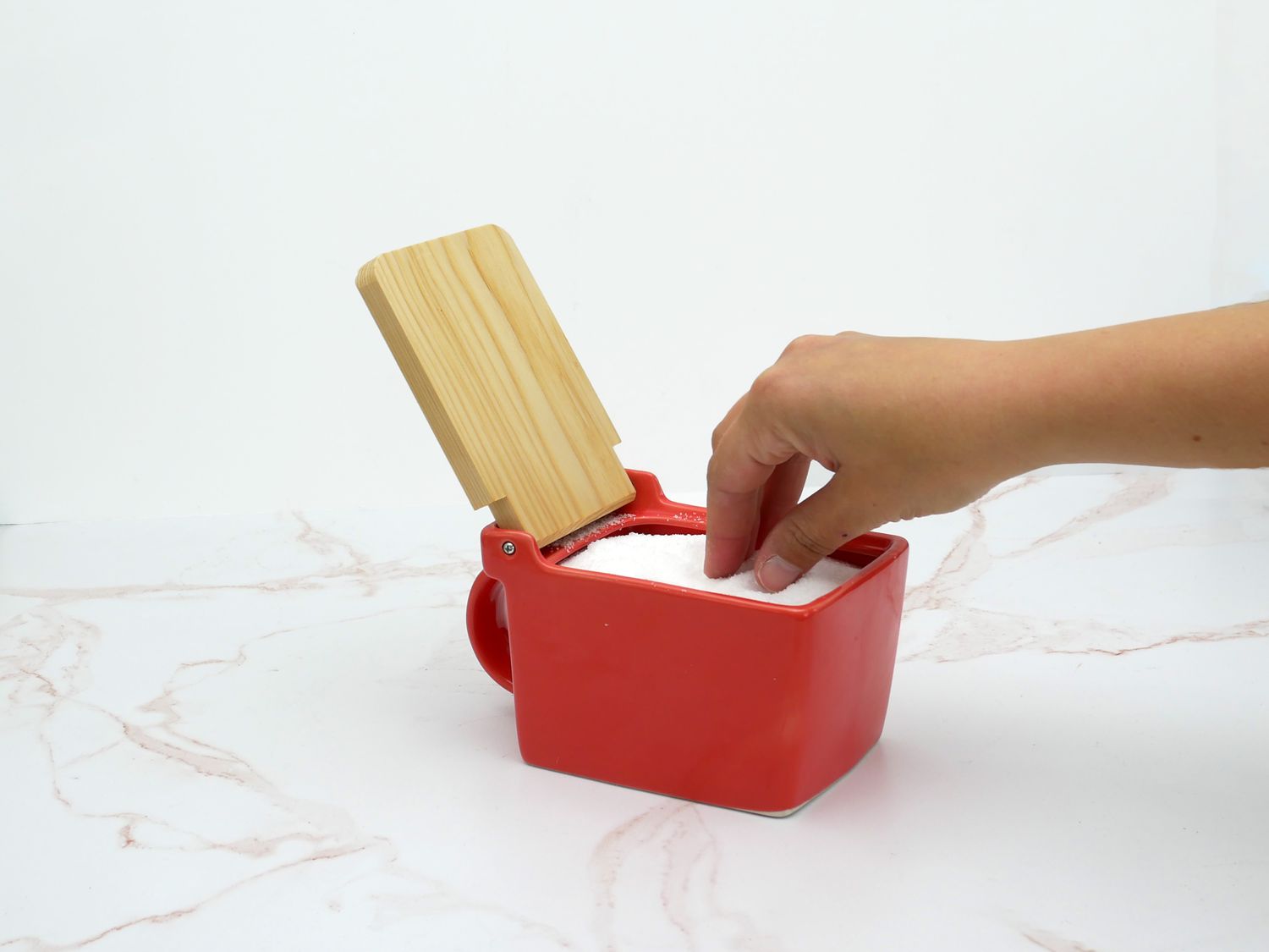 a hand taking a pinch of salt from the zerojapan salt cellar