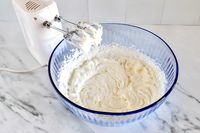 Electric mixer and whipped cream in a Pyrex bowl