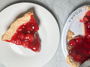 Cherry pie slices on different plates one labeled with flour type