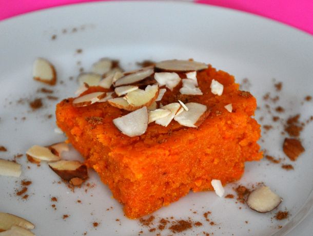 Closeup of an Indian-style spiced carrot bar, garnished with sliced almond.