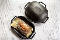 a bread pan with a loaf of bread