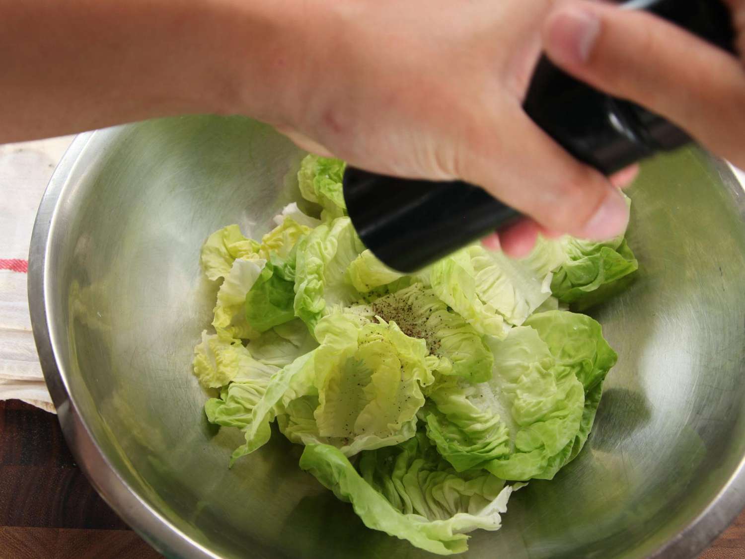 Author seasons the lettuce with freshly ground black pepper.