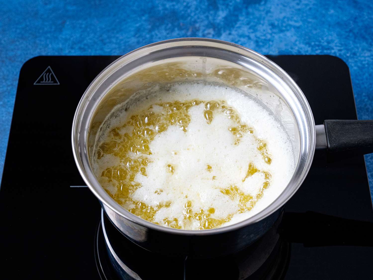 A pot of boiled butter, with broken white milk protein on top