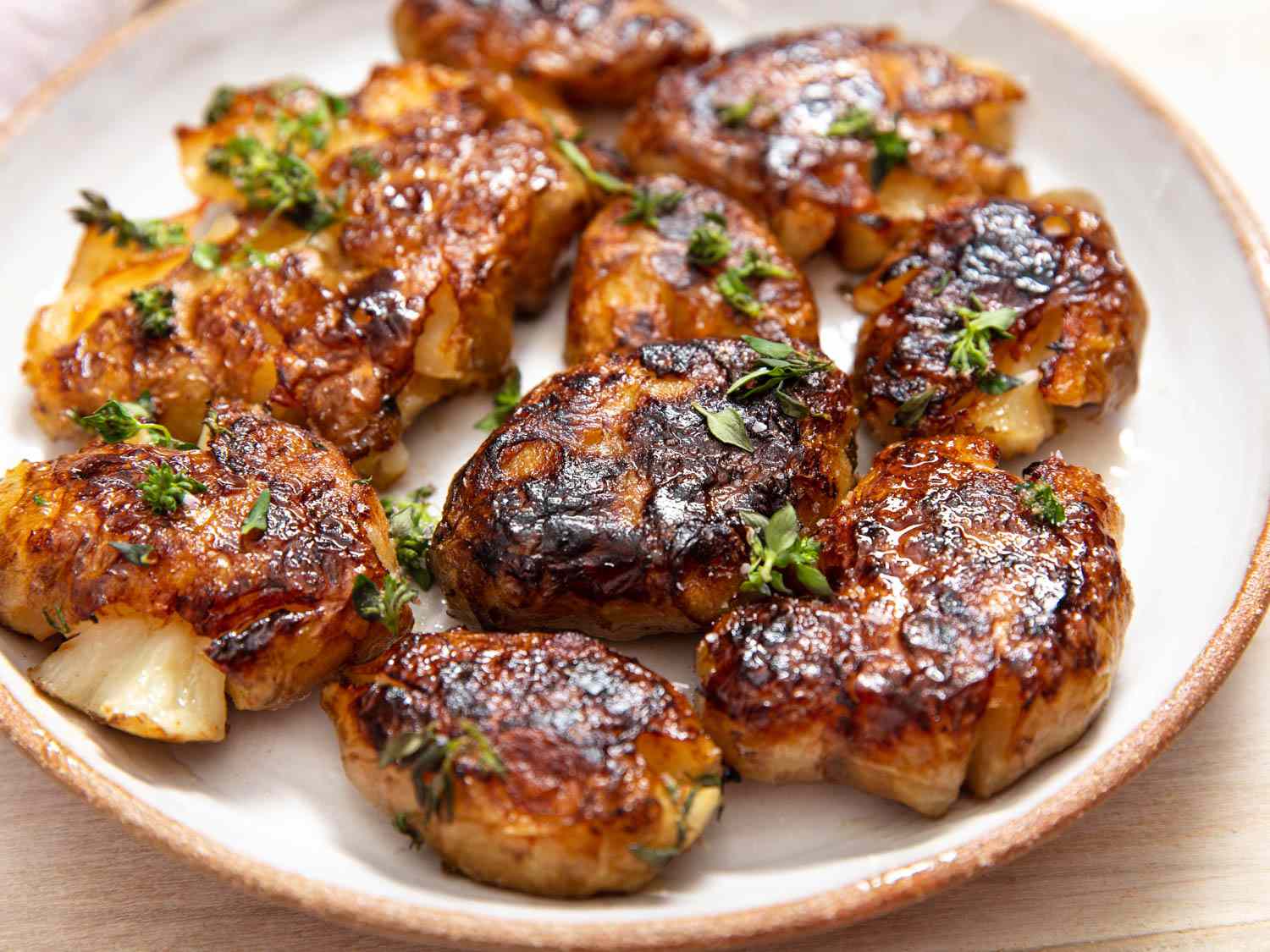 Smashed sunchokes with thyme-butter on a plate.