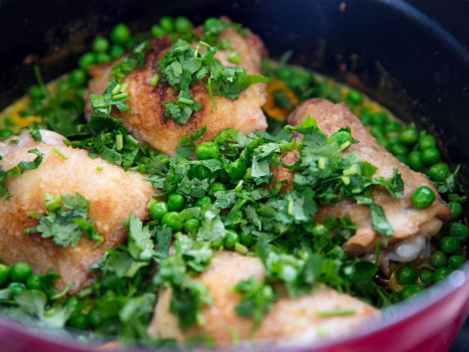 Chicken aji amarillo topped with peas and chopped cilantro.