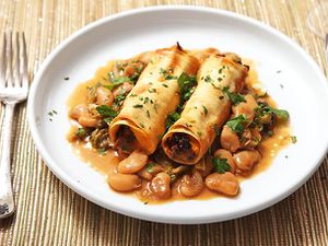 A plate of Sweet Potato and Mushroom Cannelloni, served atop Braised Escarole and Butter Beans.