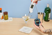 Person checking temperature of liquid in Williams Sonoma Reserve Martini Glasses