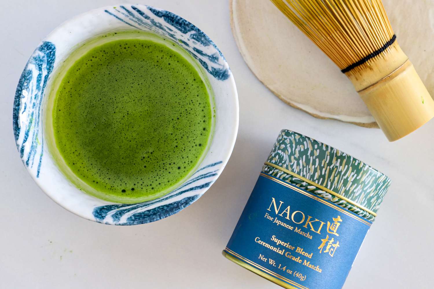 A glass of Naoki Matcha Superior Ceremonial Blend next to the container