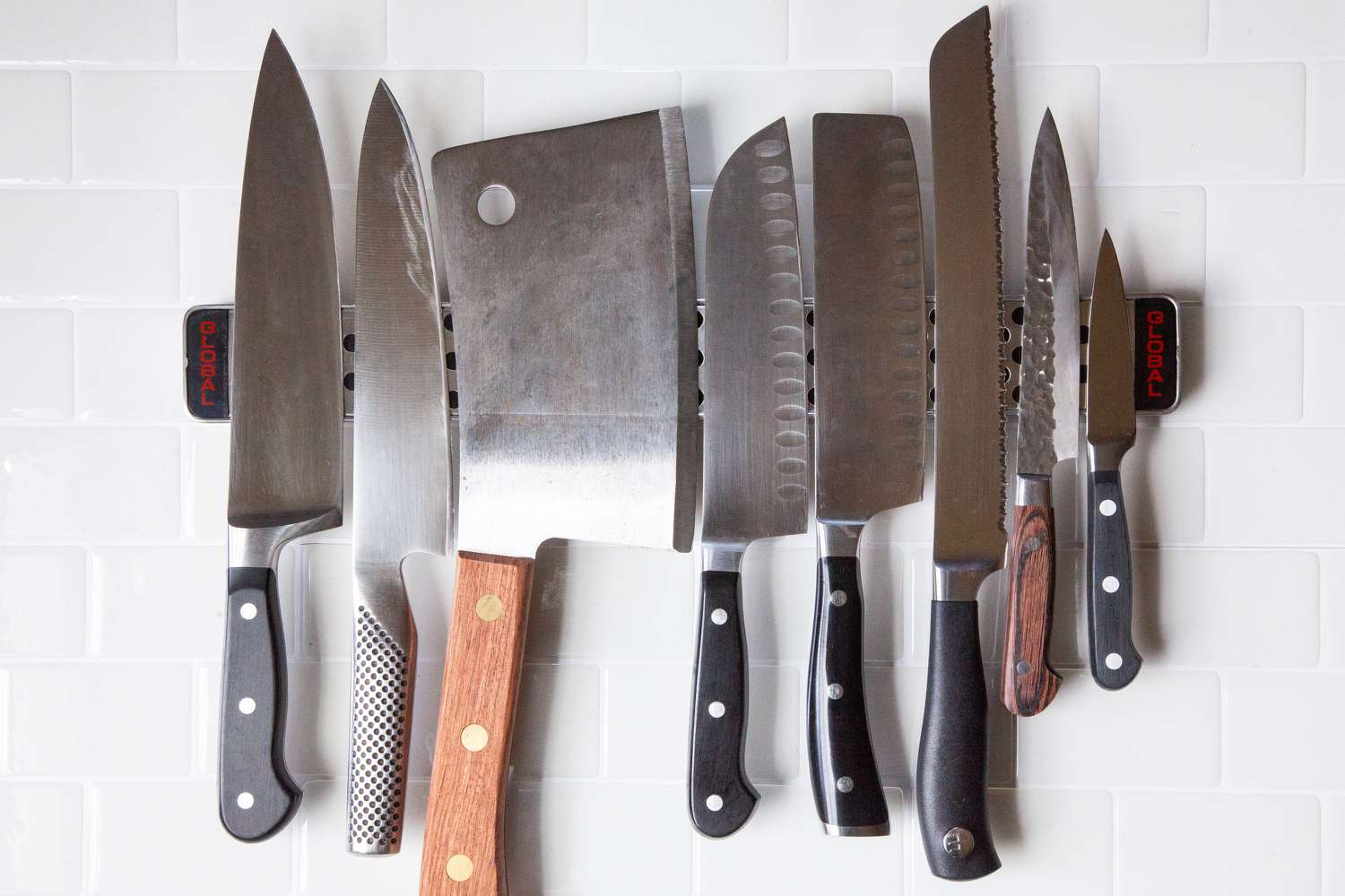 A collection of knives on a metal knife strip
