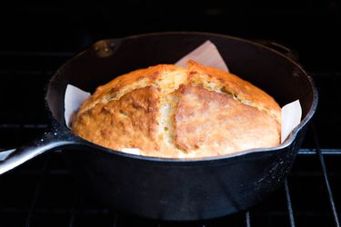 Irish soda bread in a parchment-lined cast iron skillet in the oven.