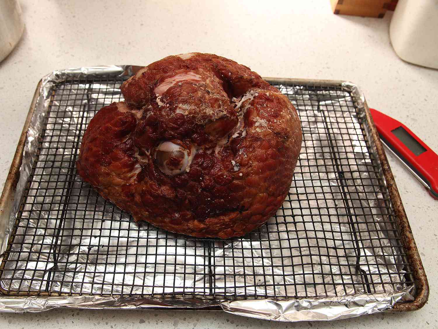 A preheated ham on a wire rack over a rimmed baking sheet. 