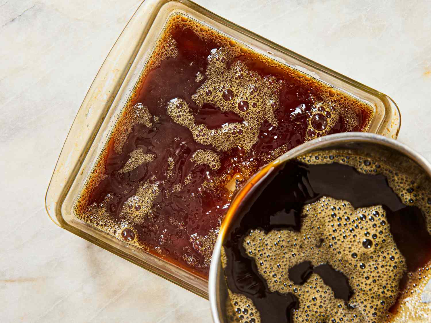 Container with coffee gelatin and a pot of liquid coffee