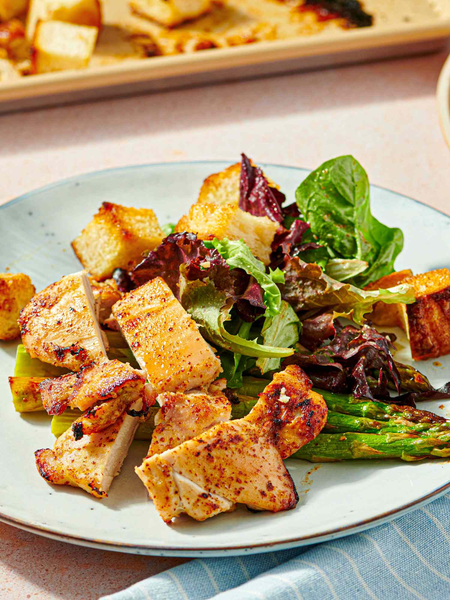 Plate of honey mustard chicken thighs with greens and roast vegetables