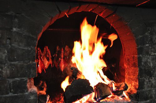 A stone hearth with a roaring fire in it.