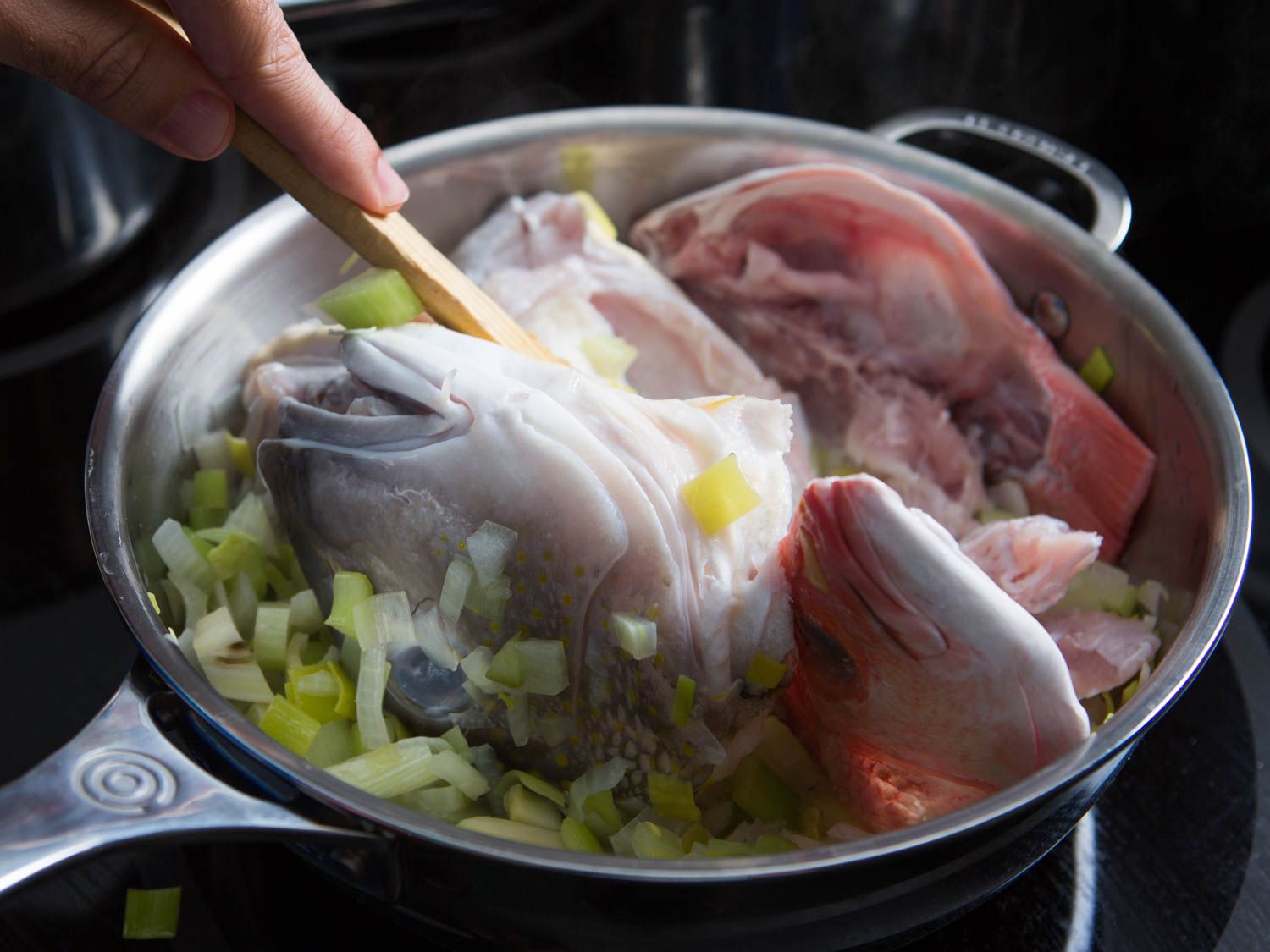 Fish bones and aromatics for fumet in a stock pot. 