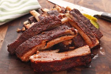 A photo of a pile of Sous Vide Barbecue Pork Ribs on a cutting board