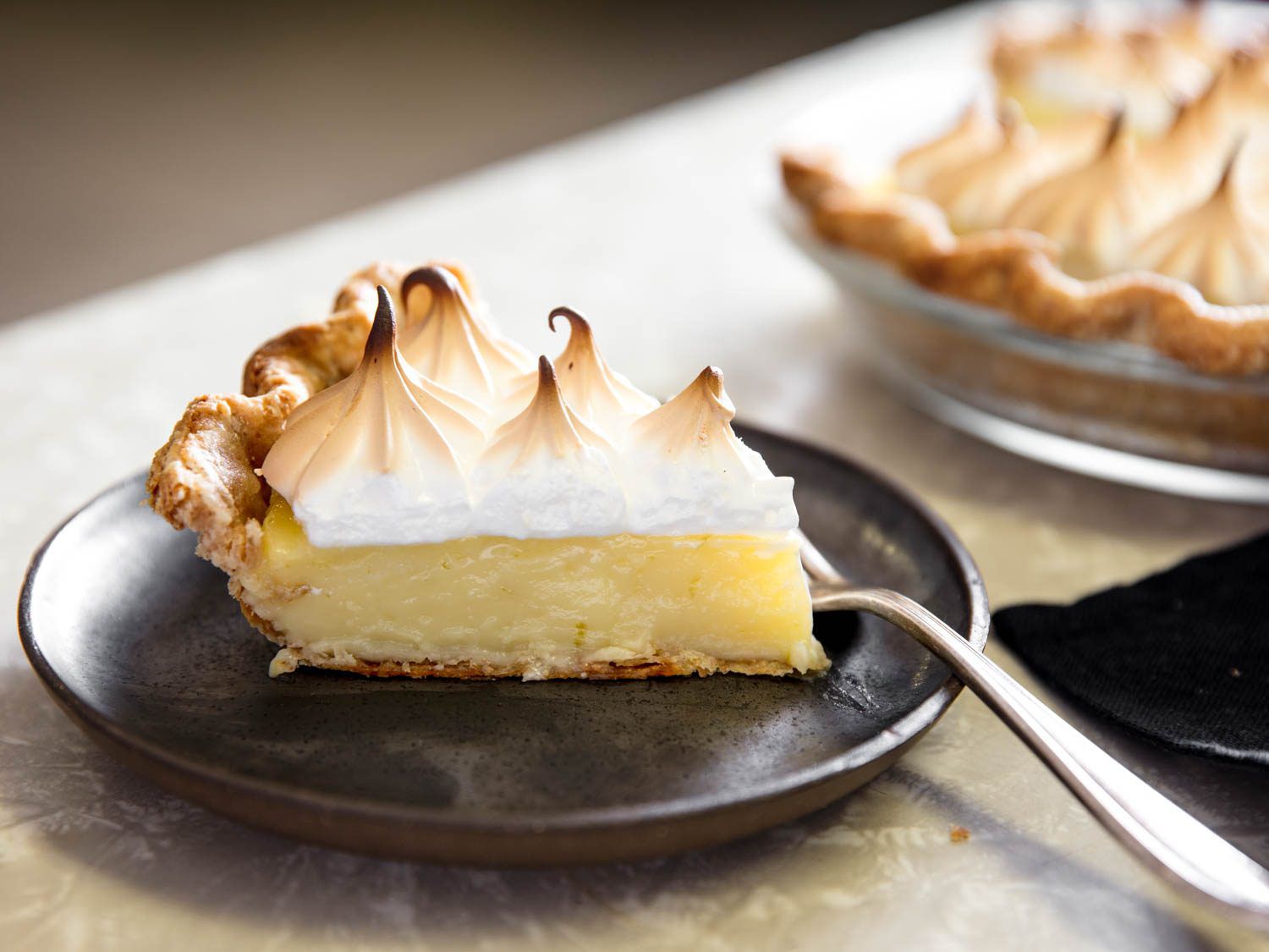 A slice of the finished pie, served on a black plate.