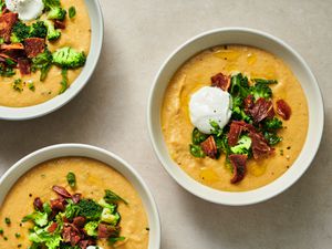 Three bowls of fully loaded vegan baked potato soup.