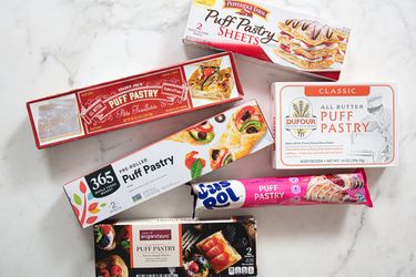 An assortment of puff pastry packaging arranged on a surface representing different brands