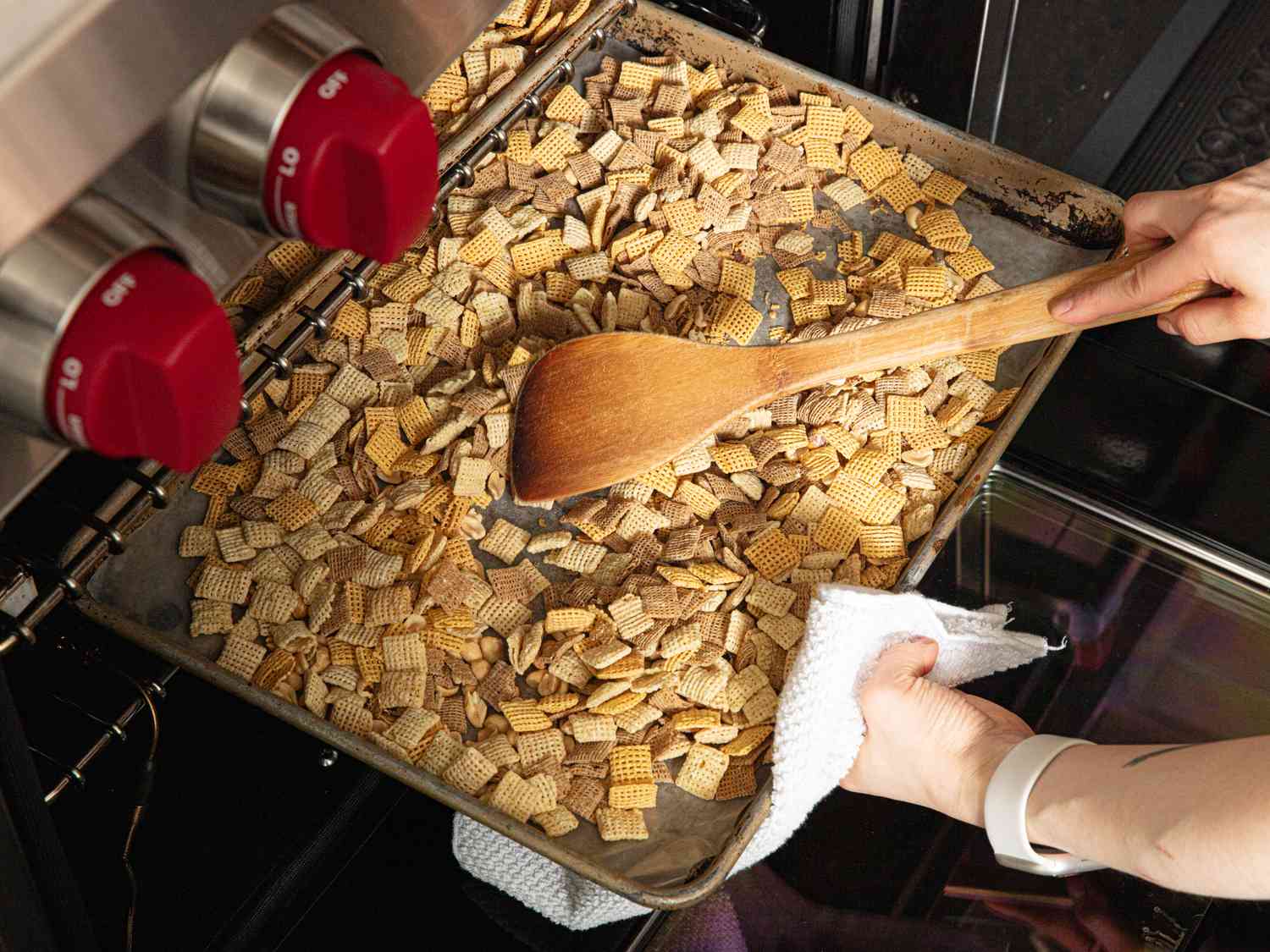 Overhead view of mixing chex mix in oven