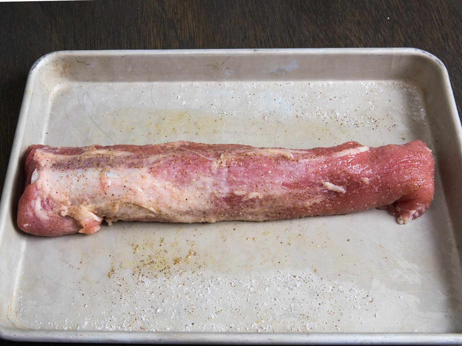 A piece of pork tenderloin on a baking sheet. 
