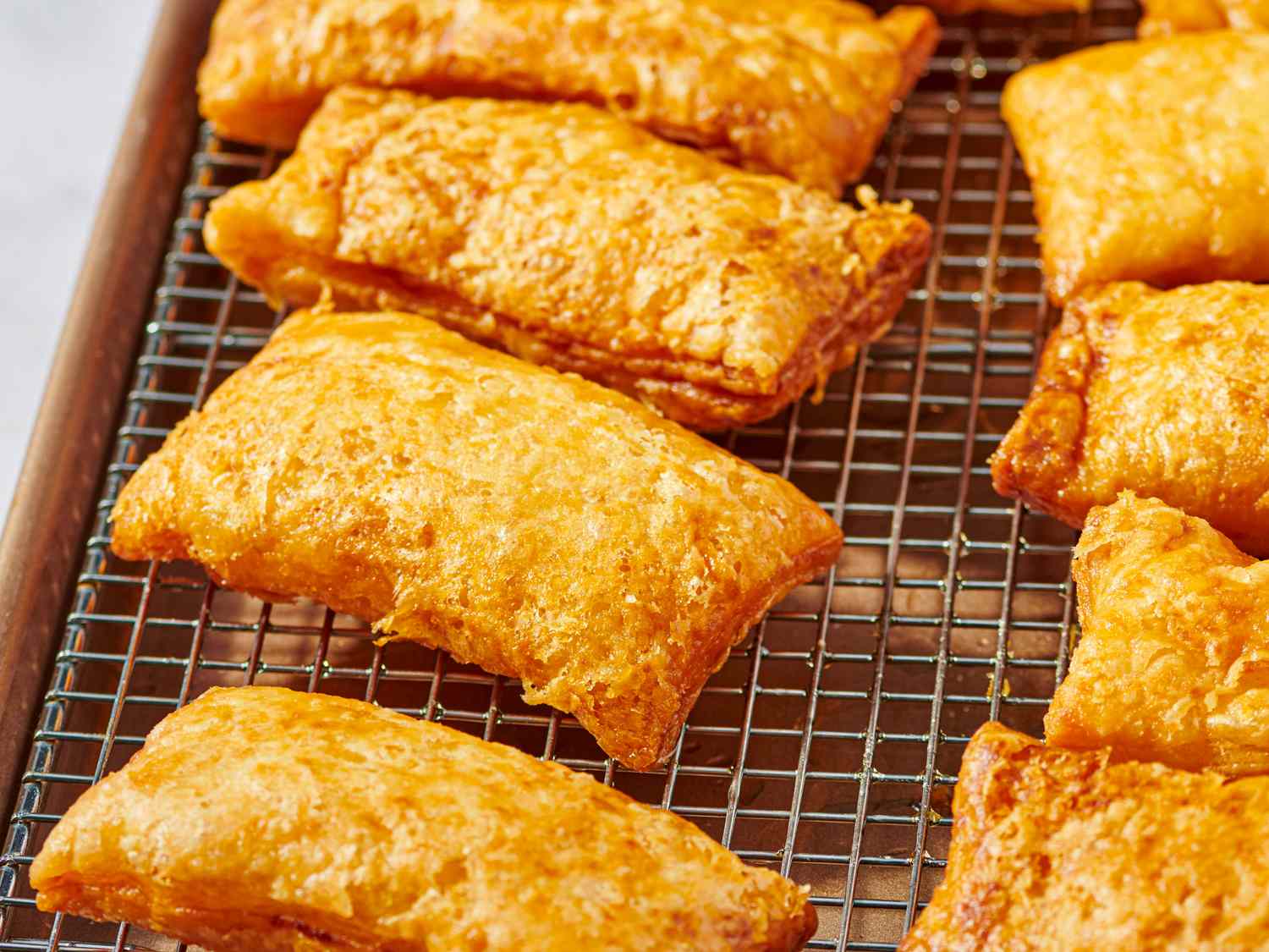 Fried apple hand pies cooling on a wire rack