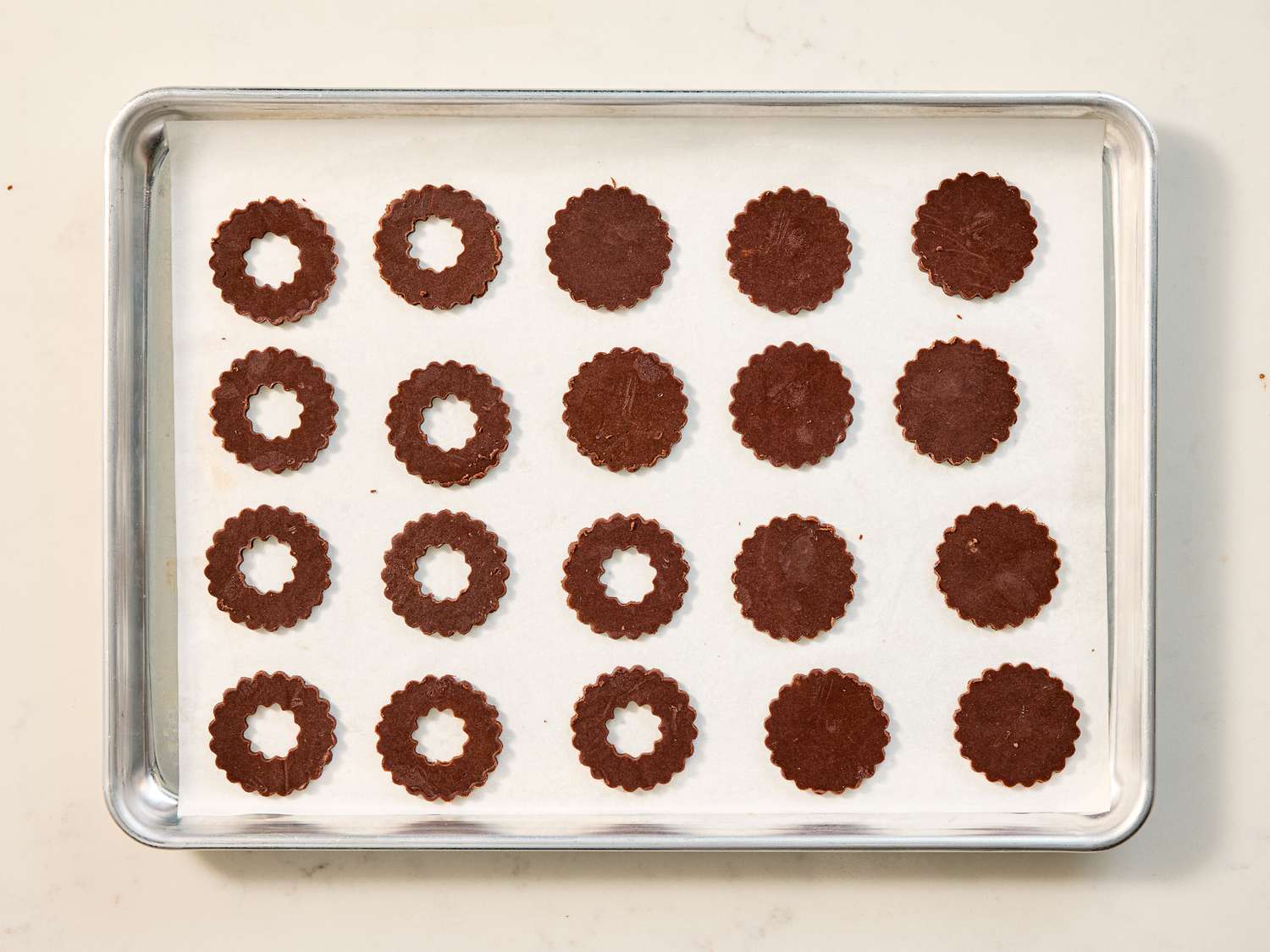Chocolate cookies arranged on a baking tray before baking