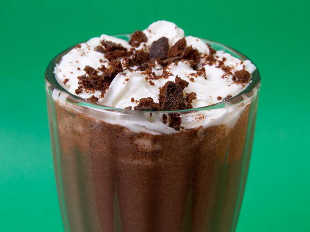 Closeup of a spiked Thin Mint milkshake, served in a thick glass.