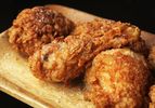 Fried chicken resting on a wooden platter