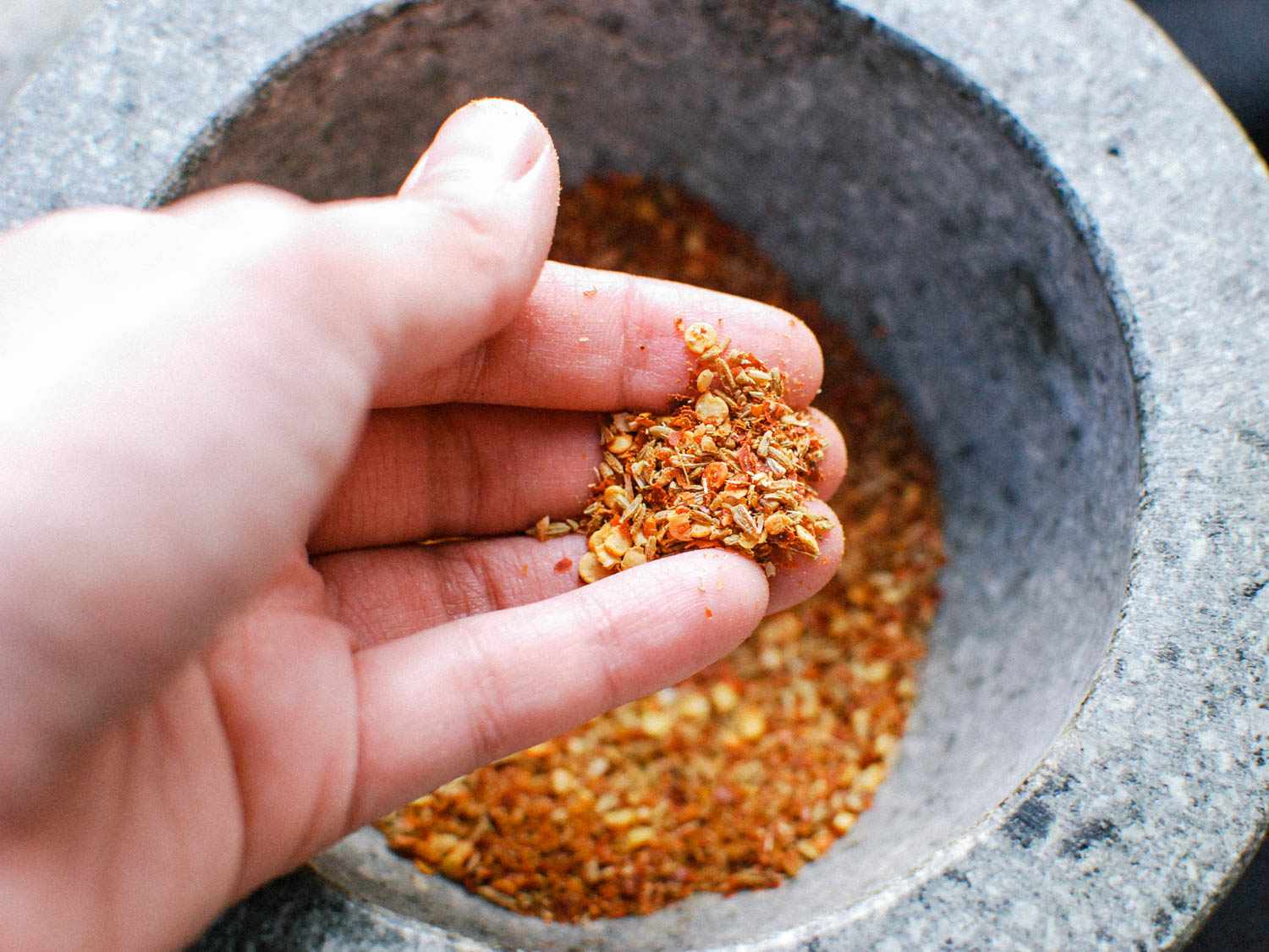 Close up of coarsely ground spices resting in a hand.