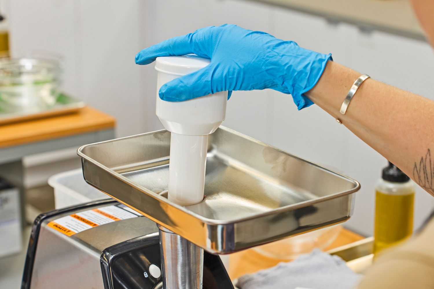 Person pushing from food tray of Weston #8 Electric Meat Grinder